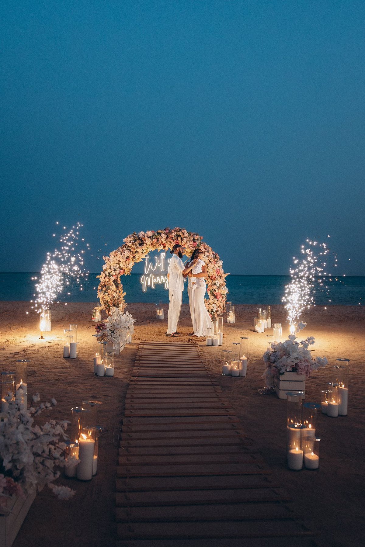 Trang trí cầu hôn trên bãi biển với hoa và nến lãng mạn 2026